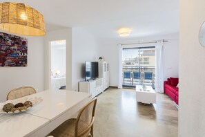 Relax in a spacious living area with a dining table, flat-screen TV, and comfortable sofa.