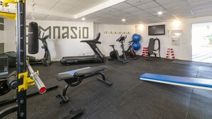 Ein Fitnessstudio mit Laufbändern, Ergometer, einem Boxsack und Gewichte.