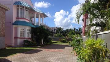 A pathway leading to a building with a blue roof and white columns.