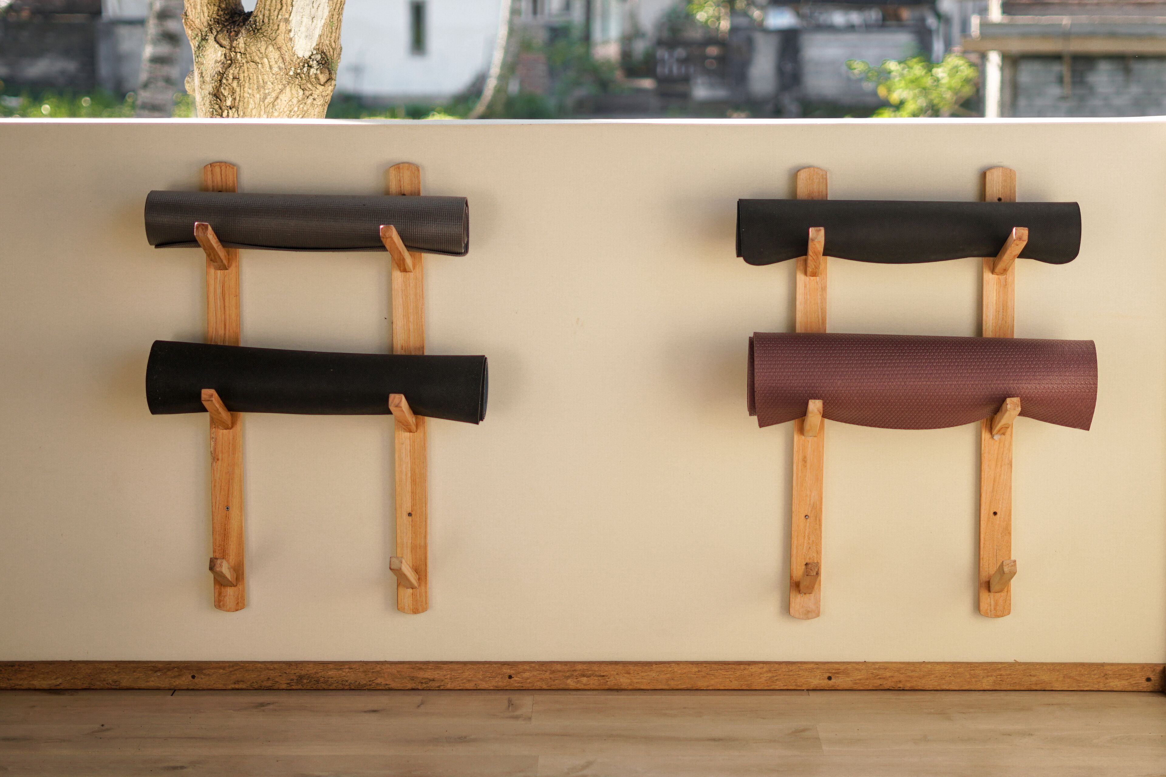 A wall-mounted rack with three rolled-up mats.