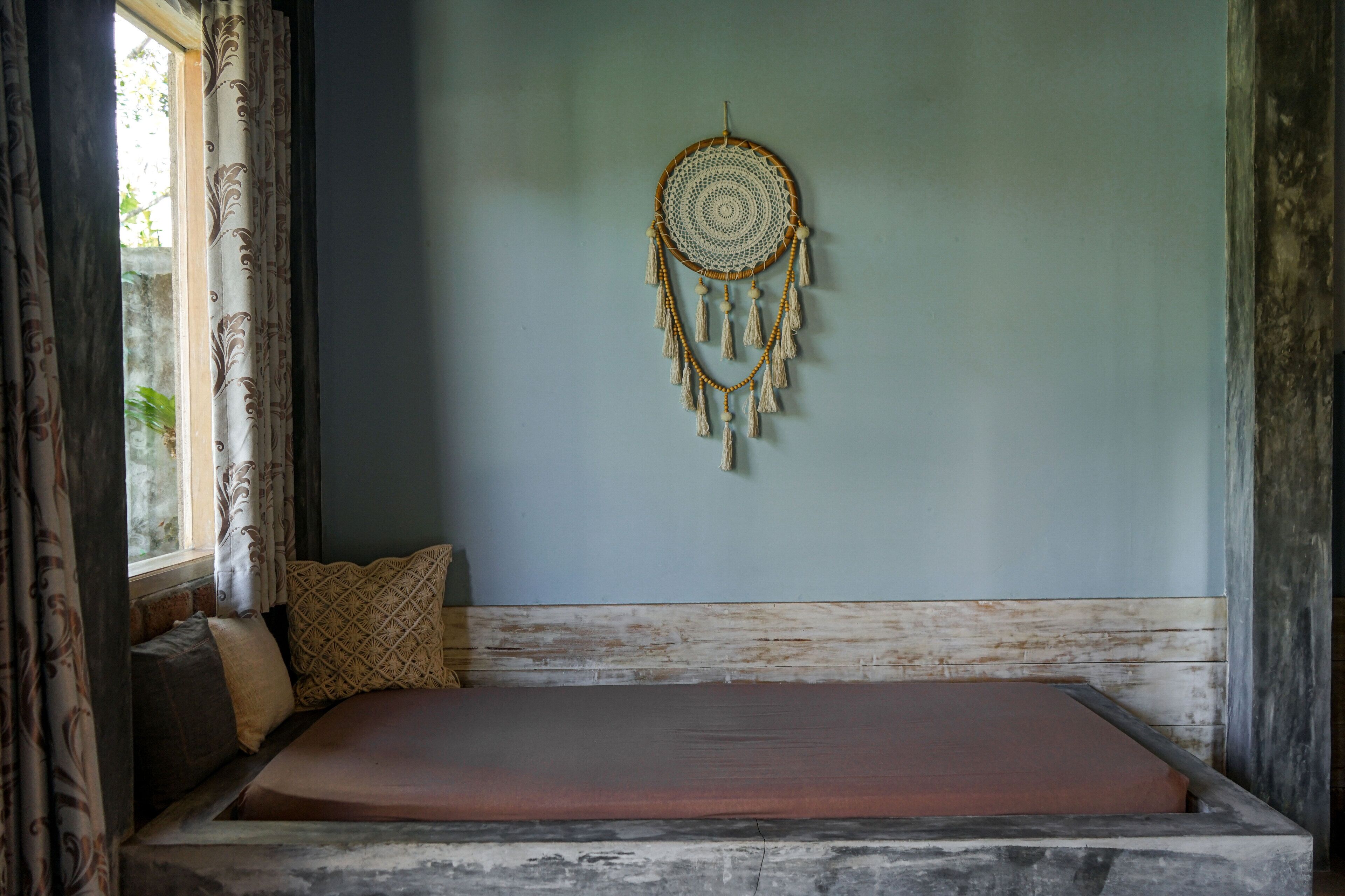Une pièce avec un lit, une décoration murale et une fenêtre avec des rideaux.