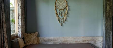 Une pièce avec un lit, une décoration murale et une fenêtre avec des rideaux.