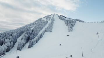 A snow-covered mountain with ski lifts and a clear sky.