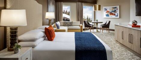 A hotel room with a large bed, a desk, a chair, and a view of the outdoors.