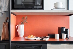 A kitchenette with a microwave, coffee maker, and a small plant.
