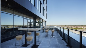 Terraza en la azotea con mobiliario exterior y vistas de la ciudad.