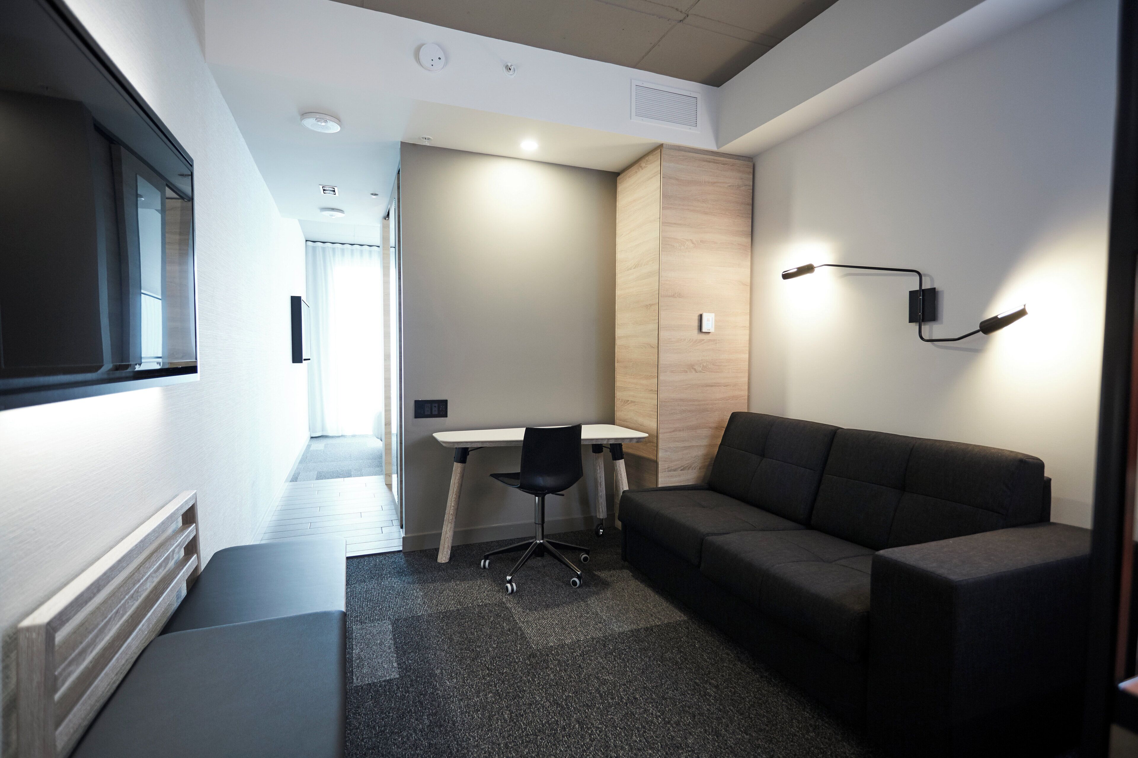 A modern room with a sofa, a desk, and a chair.