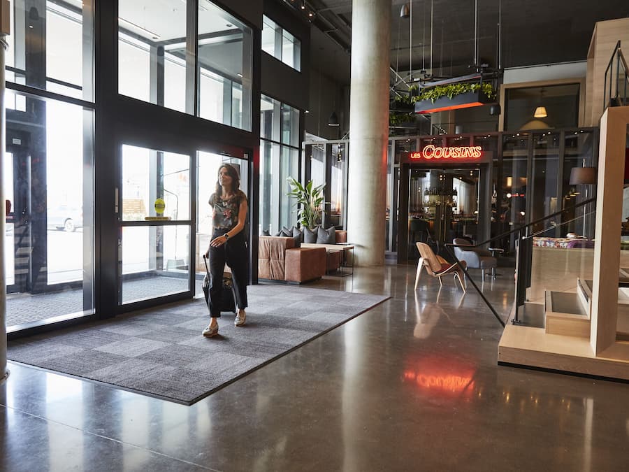 A spacious lobby with large windows, a reception area, and a seating area with sofas and chairs.