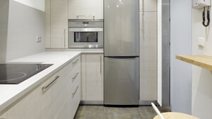 A modern kitchen with stainless steel appliances, a built-in oven, and a microwave. - Playa de Ondarreta 2 by FeelFree Rentals (San Sebastián)