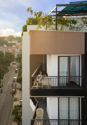 A modern building with a balcony overlooking a street. - Hanami Hotel Danang (Da Nang)