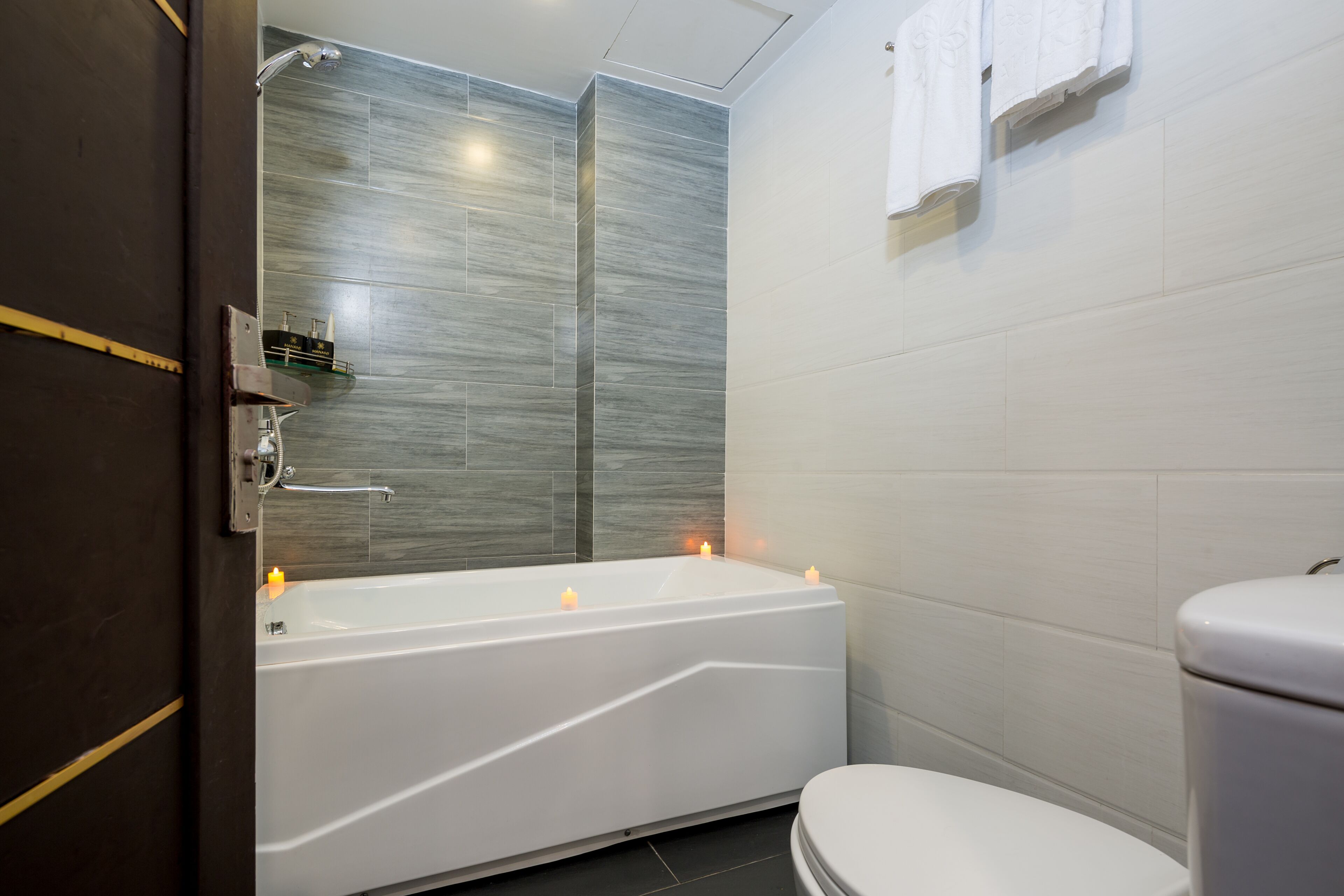 A modern bathroom with a freestanding bathtub, a toilet, and a shower area.
