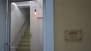 Uma escadaria com uma porta de vidro que dá para um quarto. Uma placa na parede indica "Dreamhouse Design" com classificação de cinco estrelas.