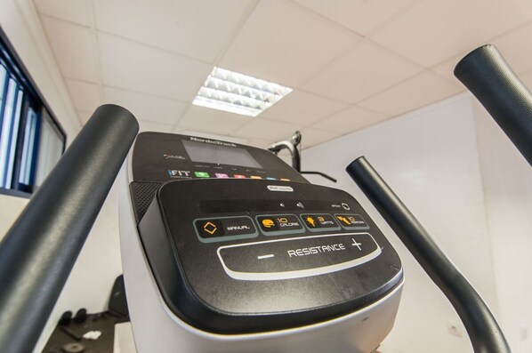 A treadmill with a digital display, control buttons, and a resistance setting.