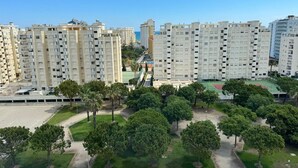 Zona residencial con edificios de apartamentos altos, espacios verdes y una cancha deportiva.