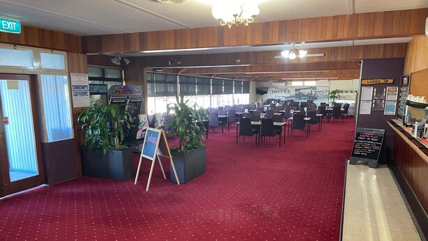 A hotel lobby with a red carpet, wooden paneling, a reception desk, and a sign for the ladies' room. - Paringa Hotel Motel (Paringa)