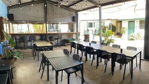 An outdoor dining area with multiple tables and chairs, a bar counter, and potted plants. - Paringa Hotel Motel (Paringa)