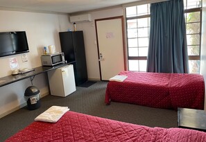 A hotel room with two beds, a TV, a microwave, a refrigerator, and a window with curtains. - Paringa Hotel Motel (Paringa)
