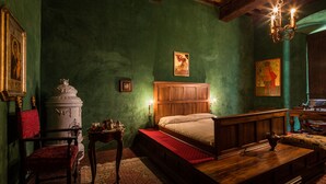 A traditional room with a wooden bed, a red chair, a white cabinet, and a chandelier. - 3BR luxury apt, walk to downtown Cortona, and amazing view over the town hall (Cortona)
