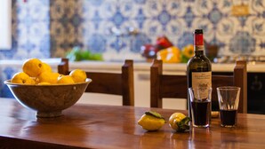 A kitchen with a bowl of lemons, a bottle of wine, and two glasses on the counter. - 3BR luxury apt, walk to downtown Cortona, and amazing view over the town hall (Cortona)