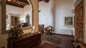 A spacious room with a wooden bench, a large mirror, and a statue on a dresser. - 3BR luxury apt, walk to downtown Cortona, and amazing view over the town hall (Cortona)