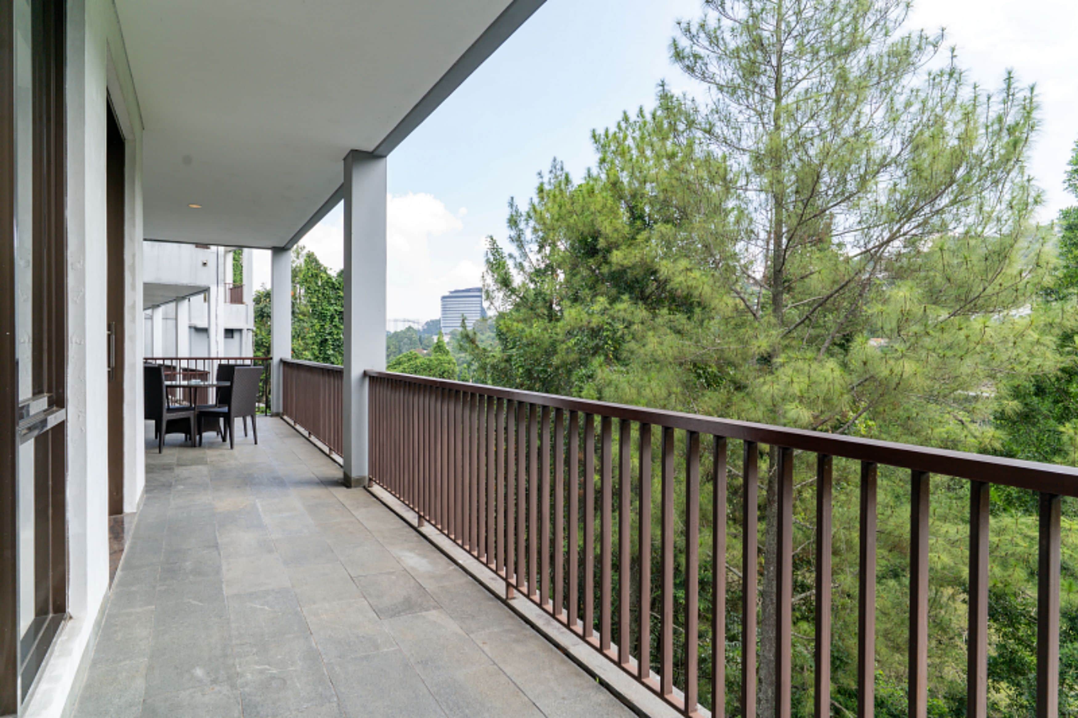 A balcony with a view of trees and buildings.