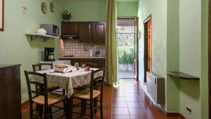 Une cuisine équipée d’une table à manger pour deux personnes, d’un four à micro-ondes et d’une machine à café.
