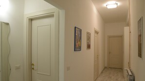 A narrow hallway with white doors, light-colored walls, and a radiator on the right. - At Casa di Rosa, your home a stone's throw from San Pietro ... (Roma)