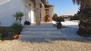 A building with a white facade, a brick entrance, and a sign indicating a sector. There are steps leading to the entrance, and potted plants are placed outside. - Modern villa with large garden and close to the sea (Catral)