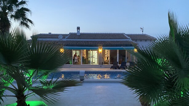 A hotel with a swimming pool, palm trees, and a tiled roof. - Modern villa with large garden and close to the sea (Catral)