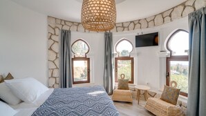 A bedroom with a bed, a small table, two chairs, and a TV mounted on the wall. - Mijas Residence (Mijas)