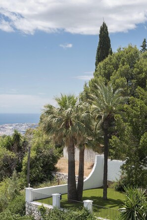 A landscaped garden with palm trees and a view of the cityscape. - Mijas Residence (Mijas)