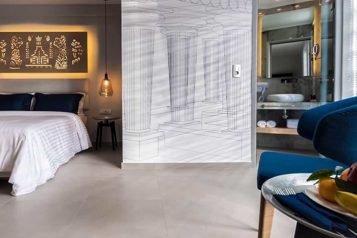 Ein modernes Hotelzimmer mit Bett, Nachttisch und einer Wand mit geometrischem Muster.