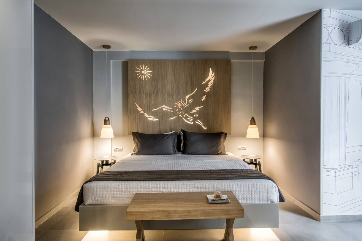 Ein modernes Schlafzimmer mit einem großen Bett, zwei Nachttischen und einem Holzkopfteil mit Sonnendesign.