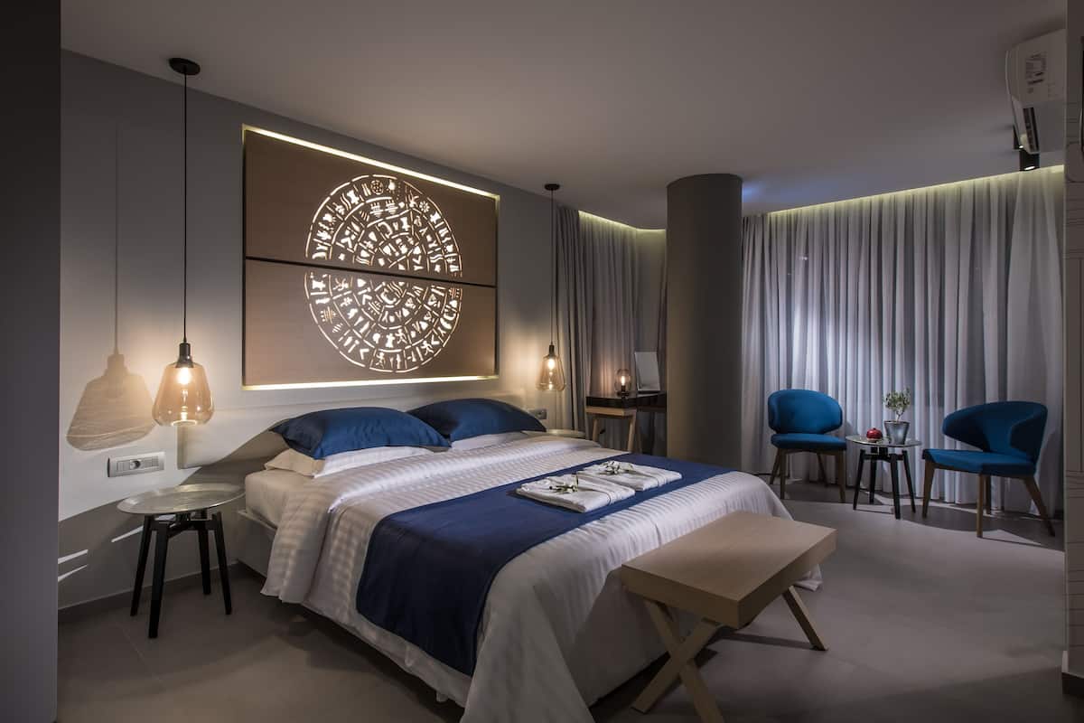 Ein modernes Schlafzimmer mit einem großen Bett, Nachttischen, einem Schreibtisch und einem Stuhl.
