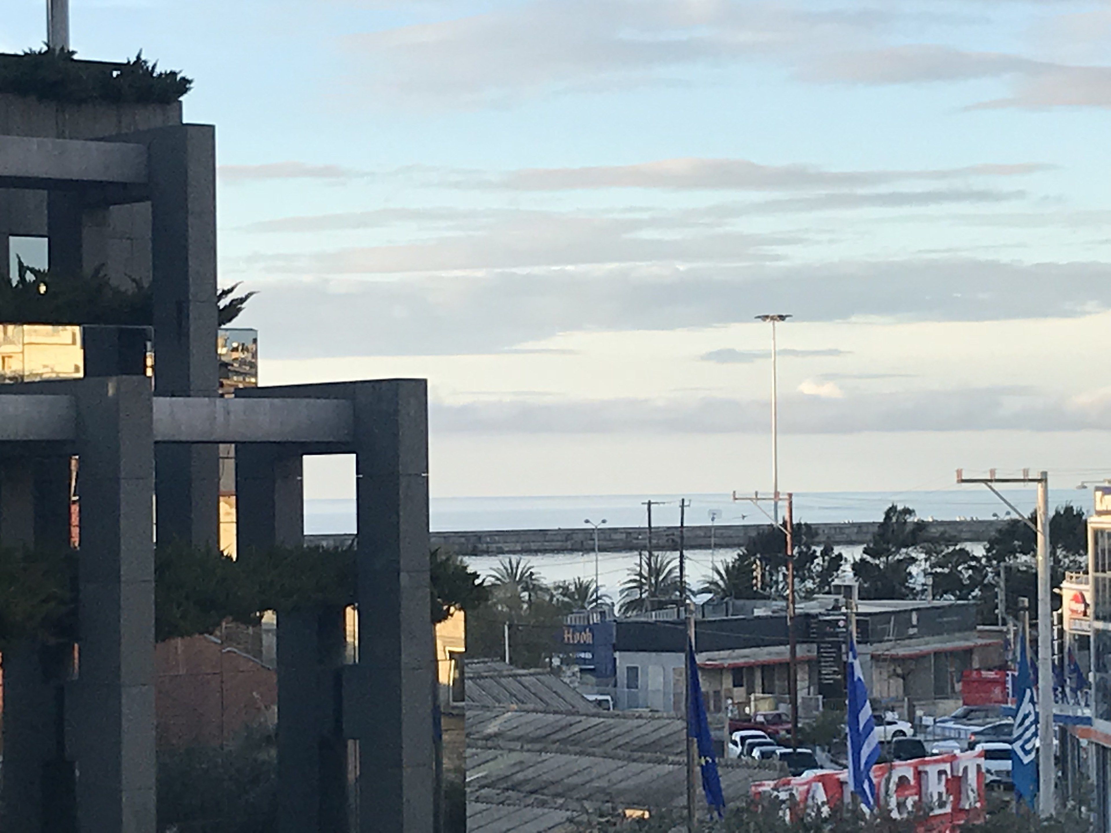 A view of a coastal area with buildings, a flag, and a body of water.