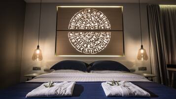 A modern hotel room with a large bed, two bedside tables, and a wall-mounted light fixture.