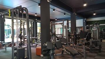Un gimnasio con diversos equipos de ejercicio, incluyendo máquinas de pesas y pesas libres.