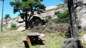 A picnic table in a natural setting with a rocky hillside in the background. - Lobeira do Mar (O Pindo-Carnota, LA Coruña)