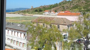 A coastal town with buildings, a beach, and hills in the background. - Lobeira do Mar (O Pindo-Carnota, LA Coruña)