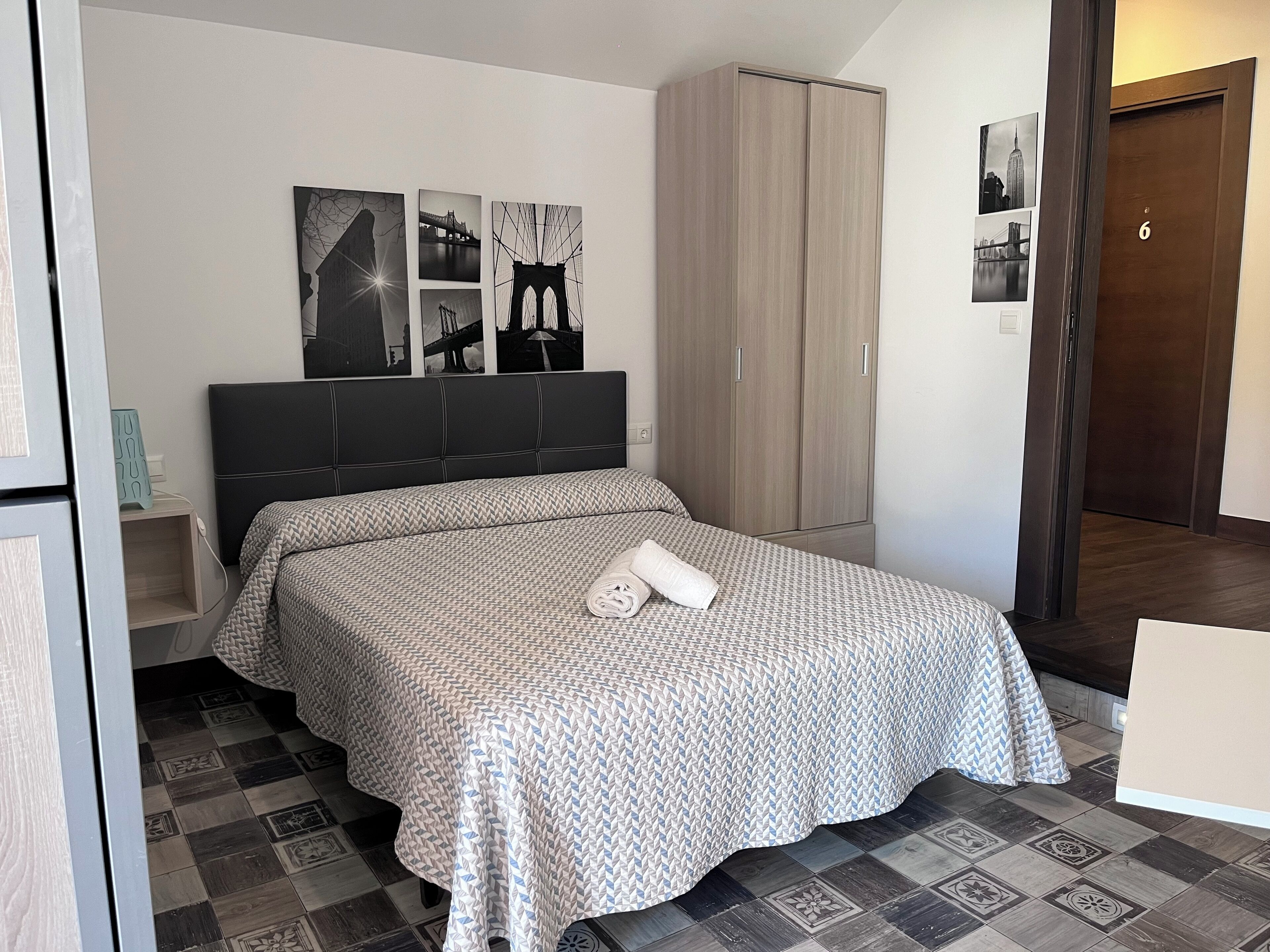 Une chambre à coucher avec un lit, une armoire et une table de chevet.