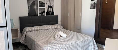 Une chambre à coucher avec un lit, une armoire et une table de chevet.