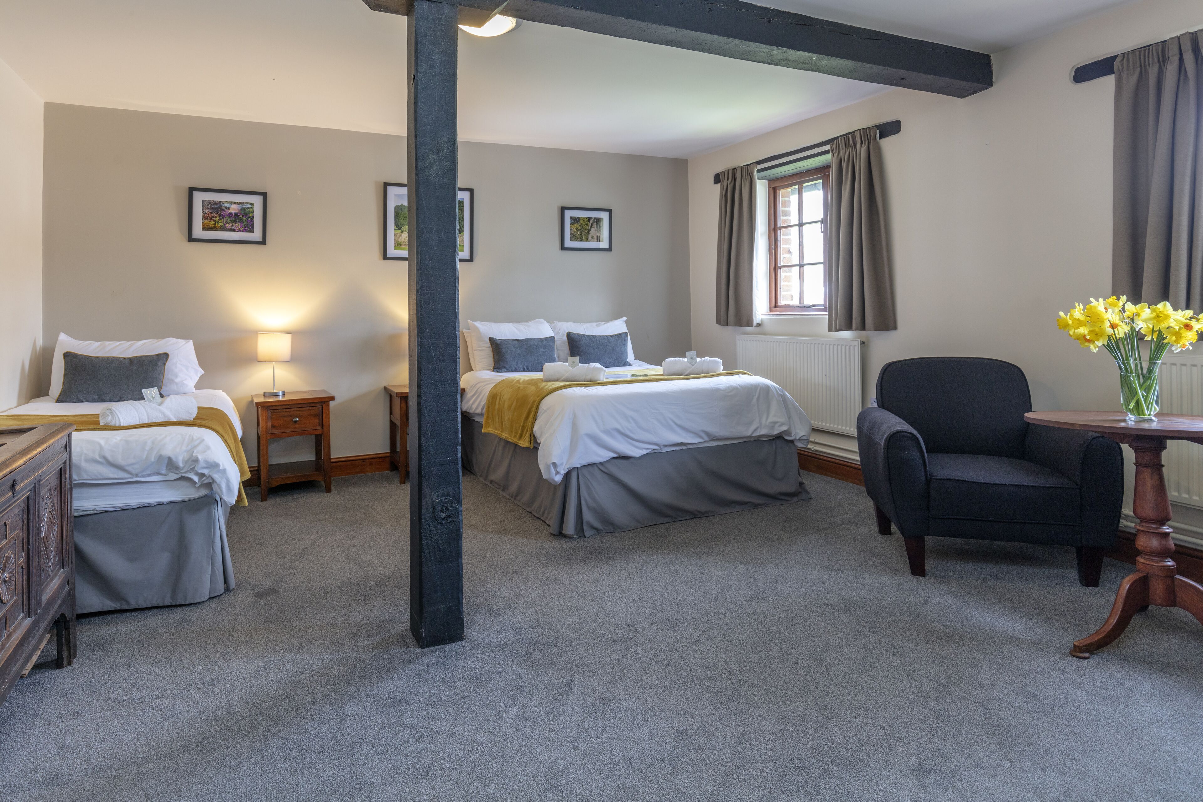 Una habitación de hotel con una cama doble, una silla, una mesita y un radiador.