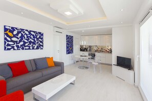 Apartamento superior (Deep Blue) | Zona de estar | Una televisión de pantalla plana, libros