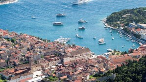 A coastal town with historic buildings, a marina with boats, and a large cruise ship in the background. - Blue Bay Residence (Hvar)