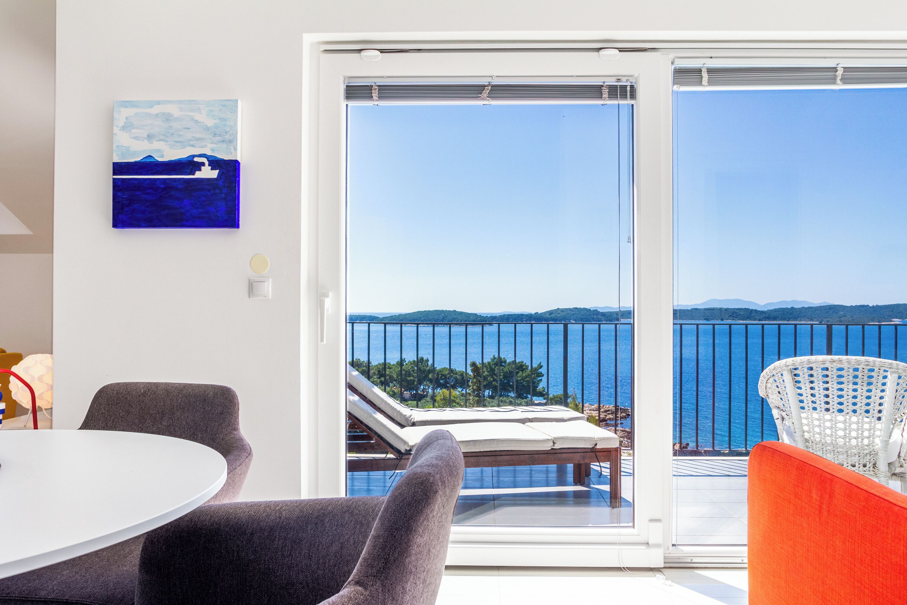 A modern room with a balcony, a round table, and two chairs.