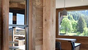 Un intérieur en bois avec une grande fenêtre, un bureau et une chaise.