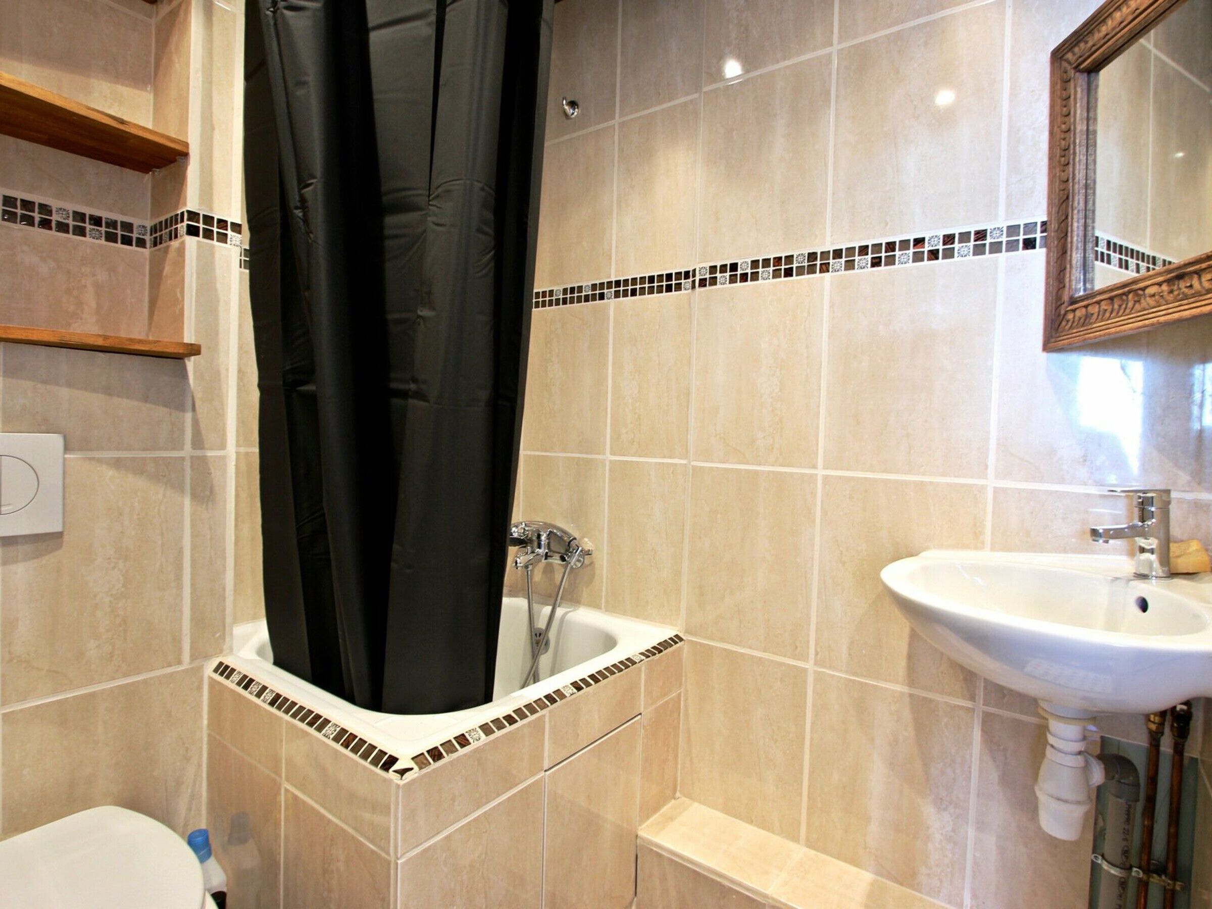 Une salle de bain avec une baignoire, un lavabo et un miroir.