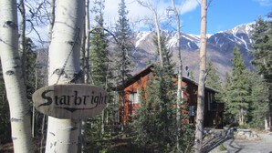 A wooden sign with the name "Starbright" in a forested area with a mountain in the background.
