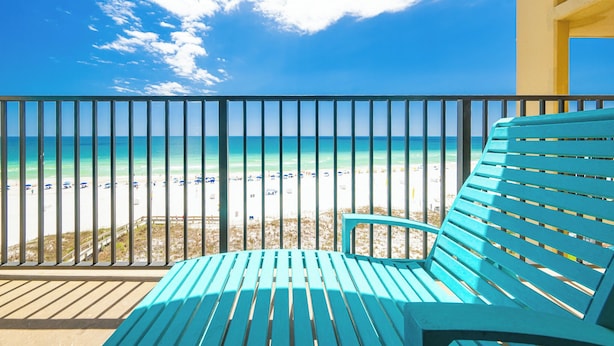 Un balcon avec vue sur une plage et l’océan.