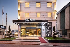 A hotel with a modern facade, large windows, and a well-lit entrance. - Nish Palace Exclusive Suites (Istanbul)